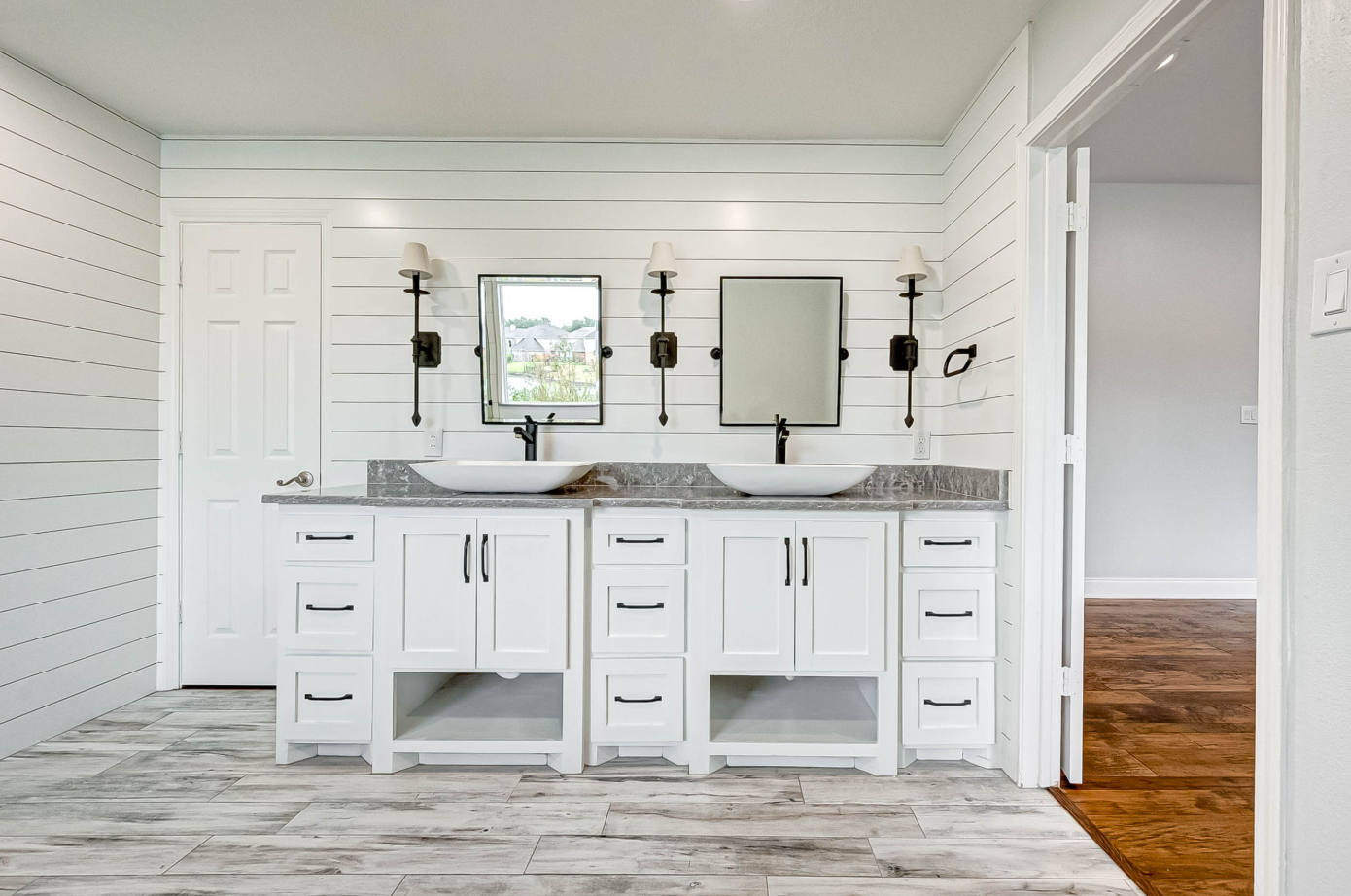 custom double vanity with white shaker cabinets, vessel sinks, and shiplap accent wall