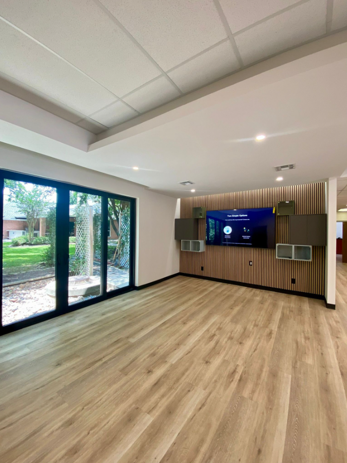 open presentation area with display wall, storage cubbies, and new wood-look flooring
