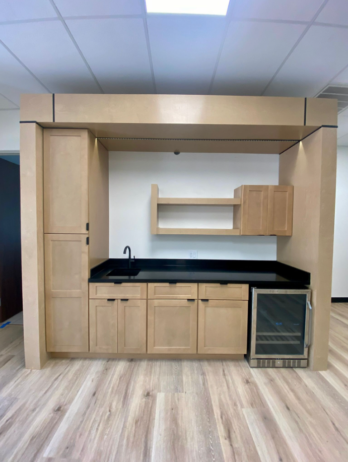 office kitchenette with custom cabinetry, stone countertops, and beverage center