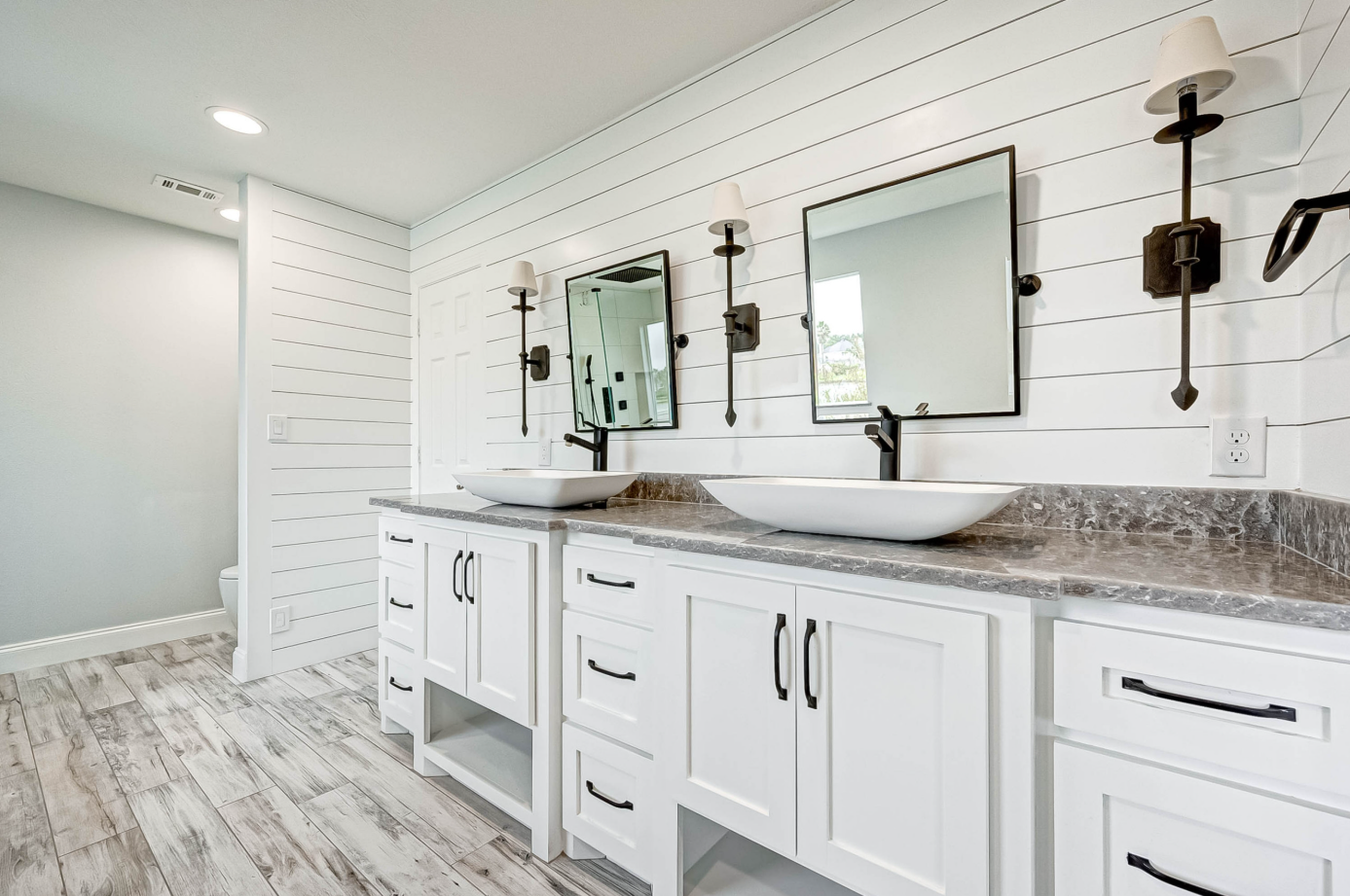 angled view of custom double vanity with matte black faucets and stone countertop