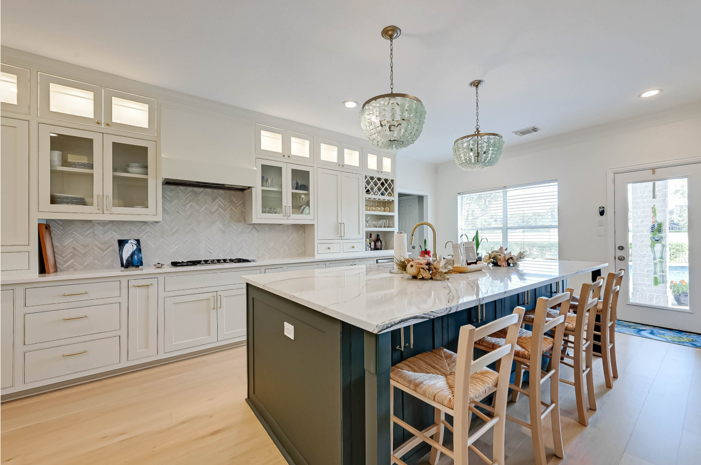 side view of remodeled kitchen with herringbone backsplash and custom white cabinets