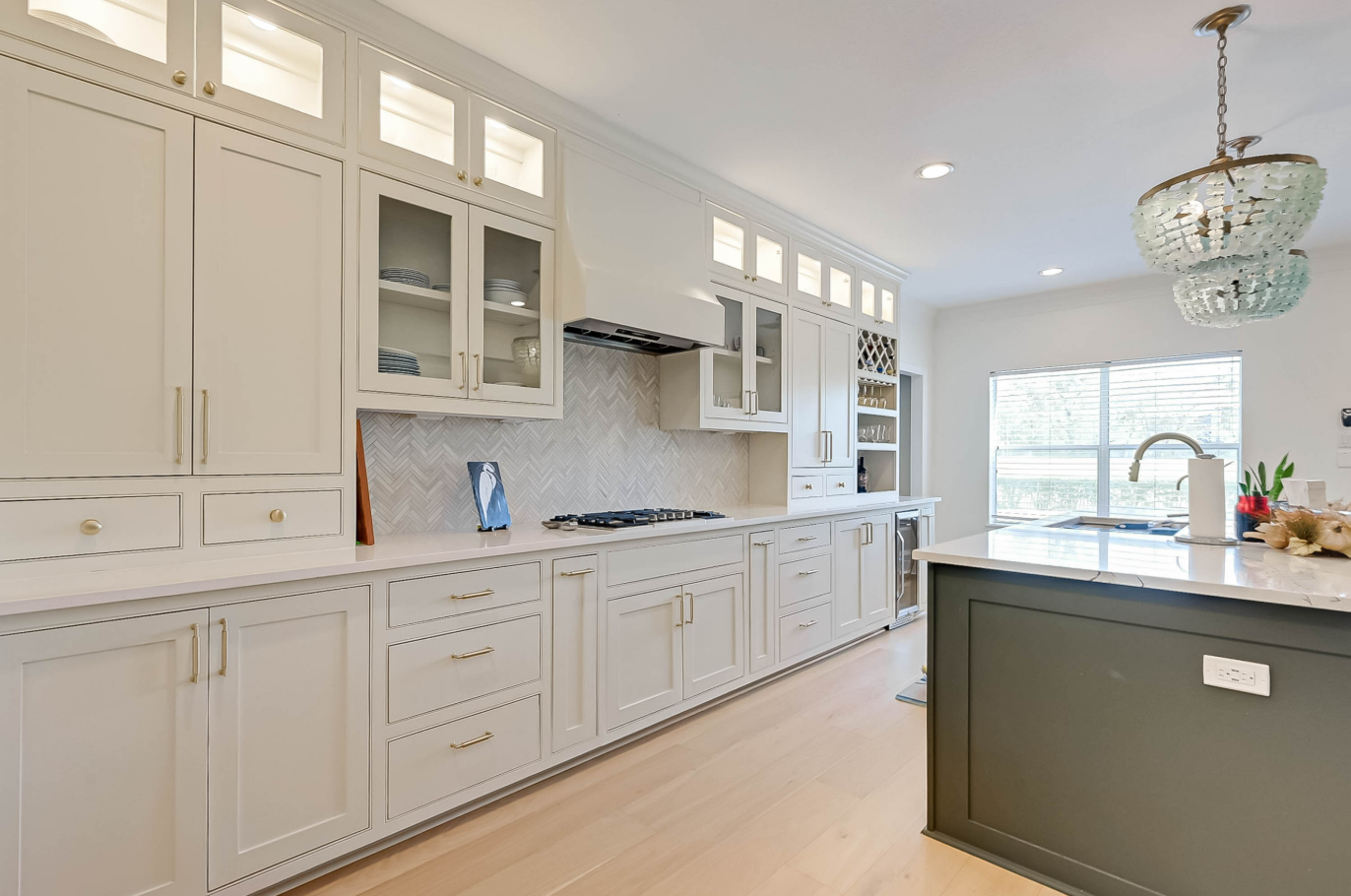 custom kitchen cabinets with insert glass doors and herringbone tile backsplash