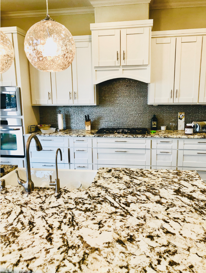view across granite countertops toward the range wall and upgraded upper cabinets