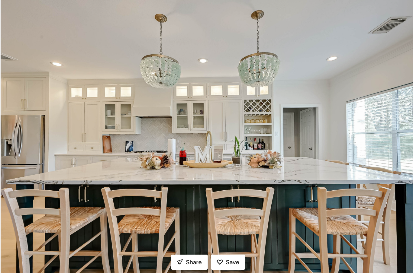 front view of new kitchen island with bar seating and chandeliers