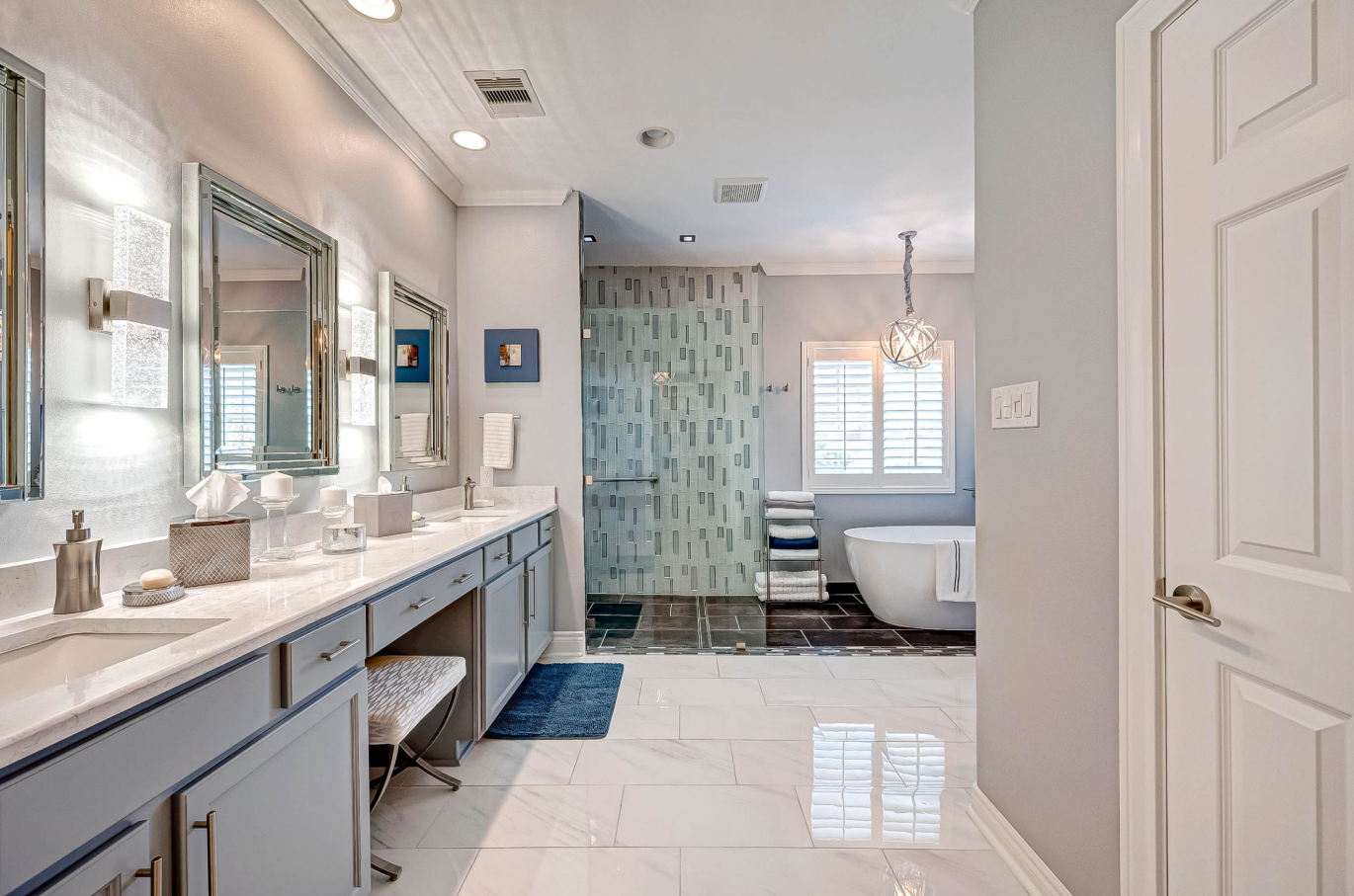 entry view of remodeled bathroom with double vanity, shower glass, and freestanding tub